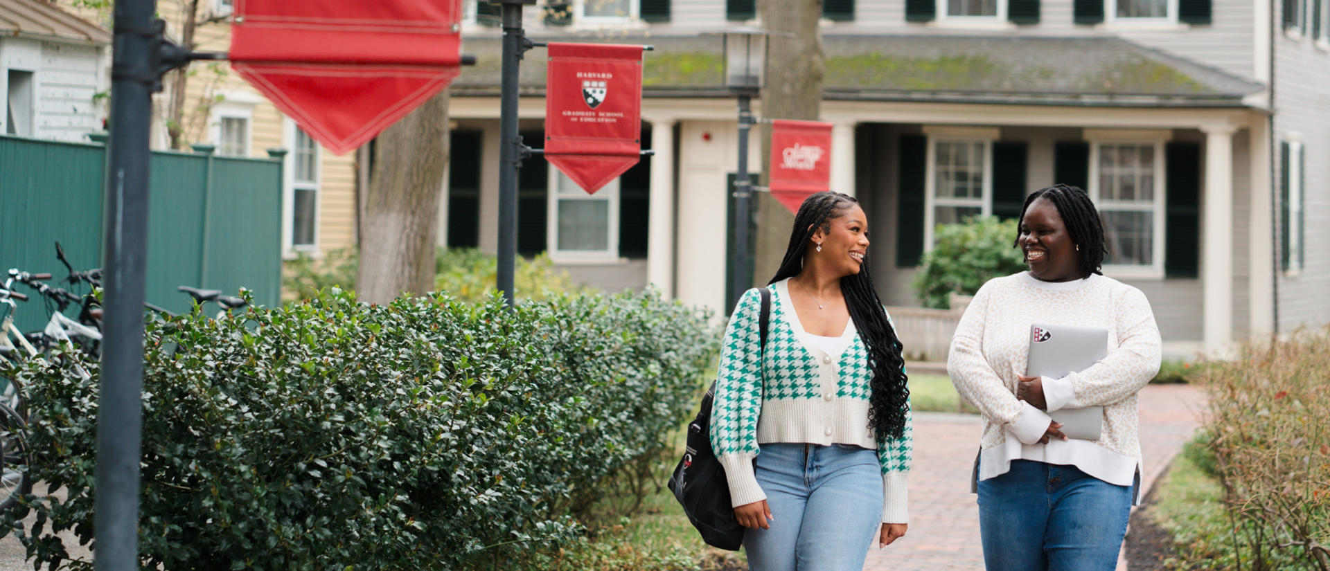 Two people having a conversation outside HGSE building